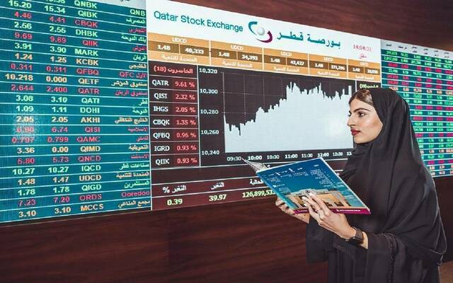 متعاملة أمام شاشة تداول ببورصة قطر