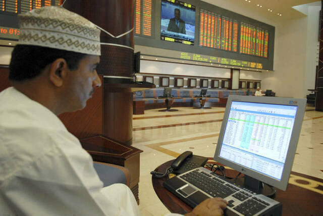 مستثمر يتابع أسعار الأسهم بسوق مسقط